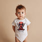 Bebé vistiendo body de deadpool, diseño inspirado en marvel. Personalizable con el nombre del bebé