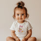 Bebé vistiendo body de daisy, diseño inspirado en disney. Personalizable con el nombre del bebé.