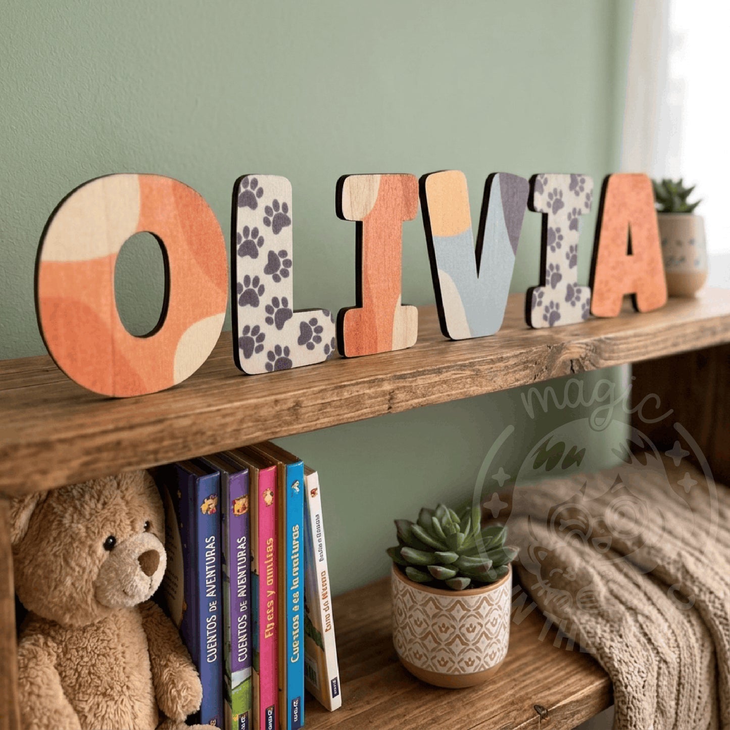 Letras de madera Bluey OLIVIA apoyadas en estantería con libros y peluches al fondo