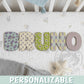 Letras decorativas de madera con estampados Monsters Inc formando el nombre BRUNO en cuna de bebé