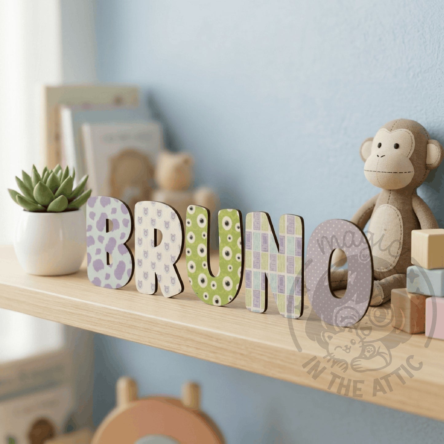 Letras de madera Monsters Inc BRUNO apoyadas en estantería con planta y peluche al fondo