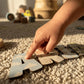 Detalle mano de niño tocando letras decorativas de madera con estampados Toy Story