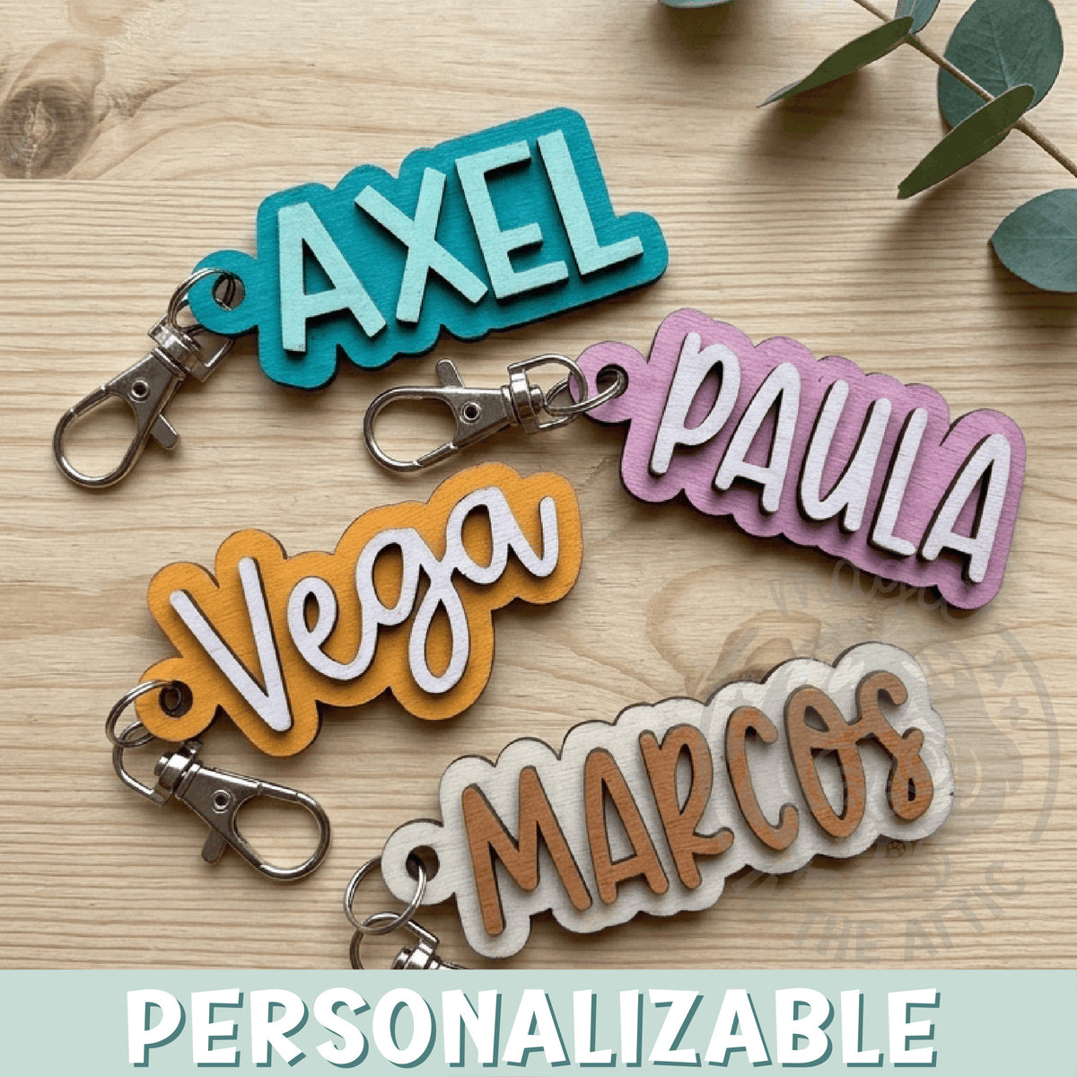 Llaveros de madera personalizados con nombre en flatlay sobre mesa de madera