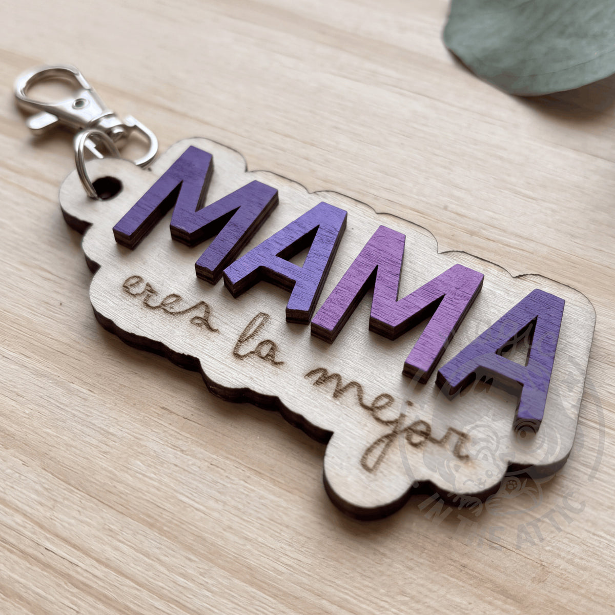 Llavero de madera personalizados con nombre y frase Mamá eres la mejor, puesto en flatlay sobre mesa de madera