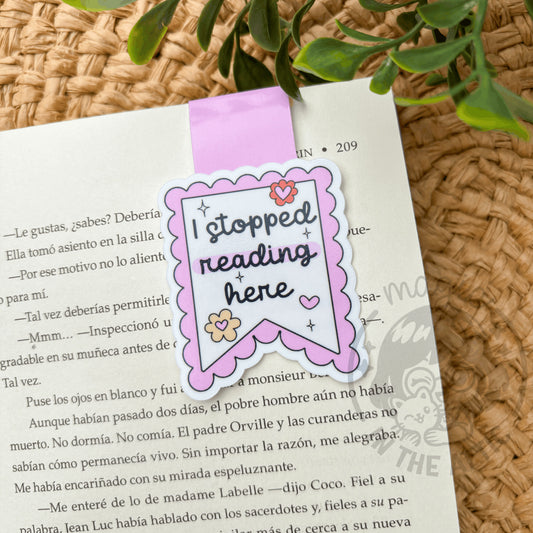 Marcapáginas imantado 'I stopped reading here' colgado en un libro abierto